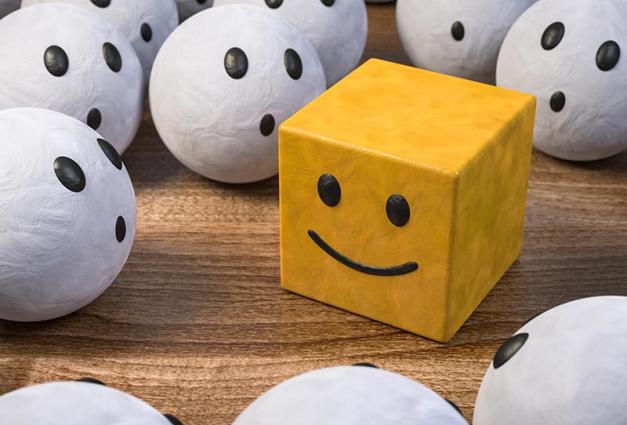 Illustration of yellow box with smiley face surrounded by white balls with concerned faces