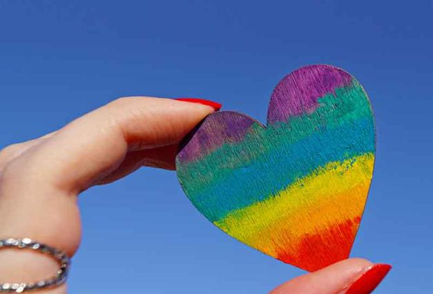 Woman holding rainbow-colored heart