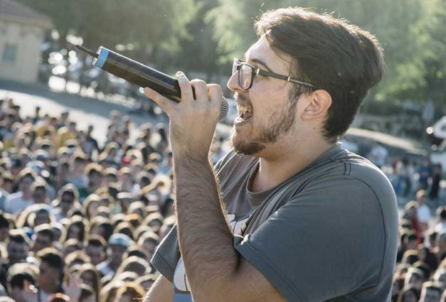 Man speaking into microphone in front of a crowd of people