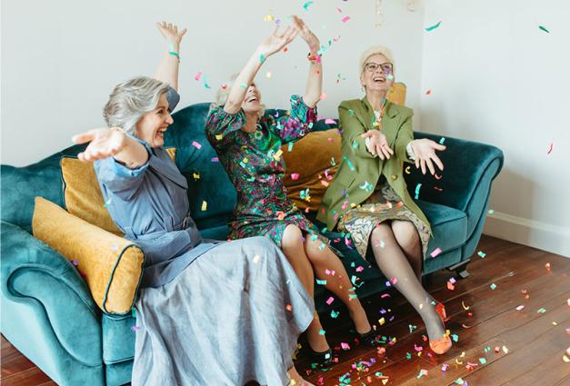 Three senior women celebrating with confetti