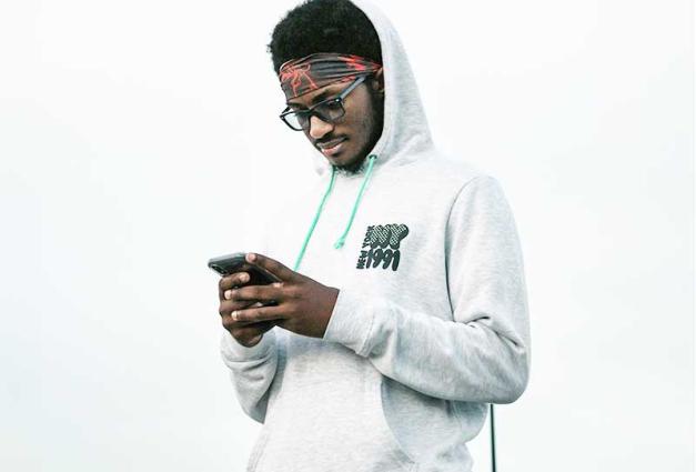 young Man wearing a hoodie and looking at a phone