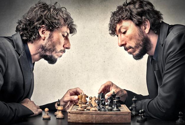 Image of a man playing chess against himself