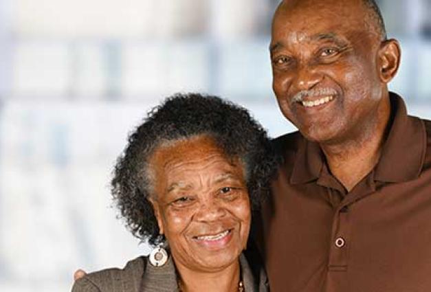 Smiling elderly couple stand close to each other