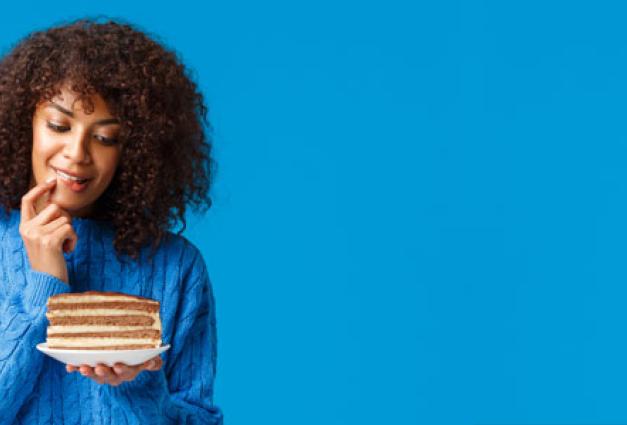 Black woman looking at piece of cake