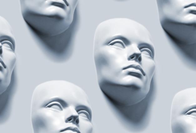 Image of expressionless gray masks on a gray wall background