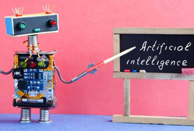 Image of robot toy pointing to "Artificial Intelligence" written on a chalkboard