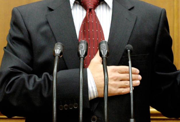 Image of politician being sworn in with microphones in the foreground