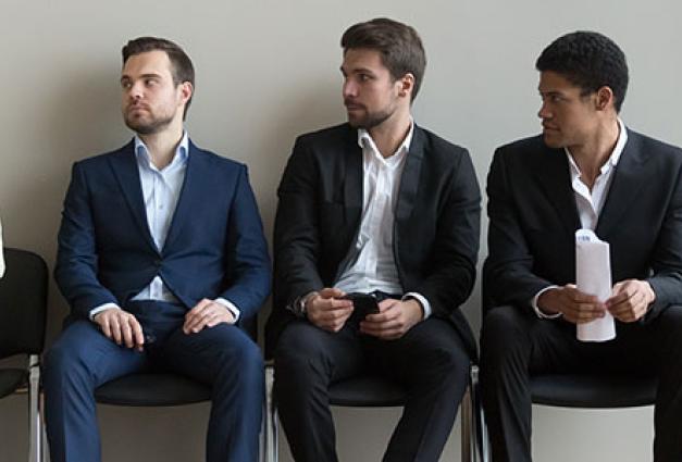 Diverse male applicants looking at female rival waiting for interview