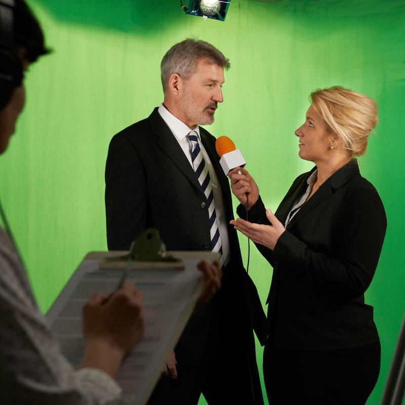 Female Presenter Interviewing In Television Studio With Crew
