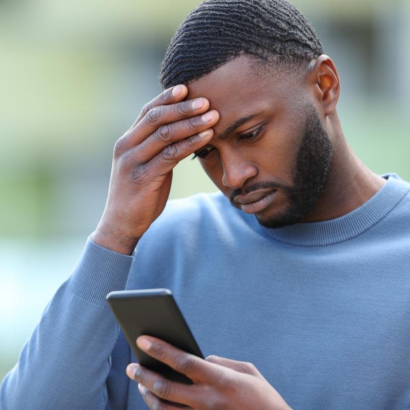 Worried Black man checking phone