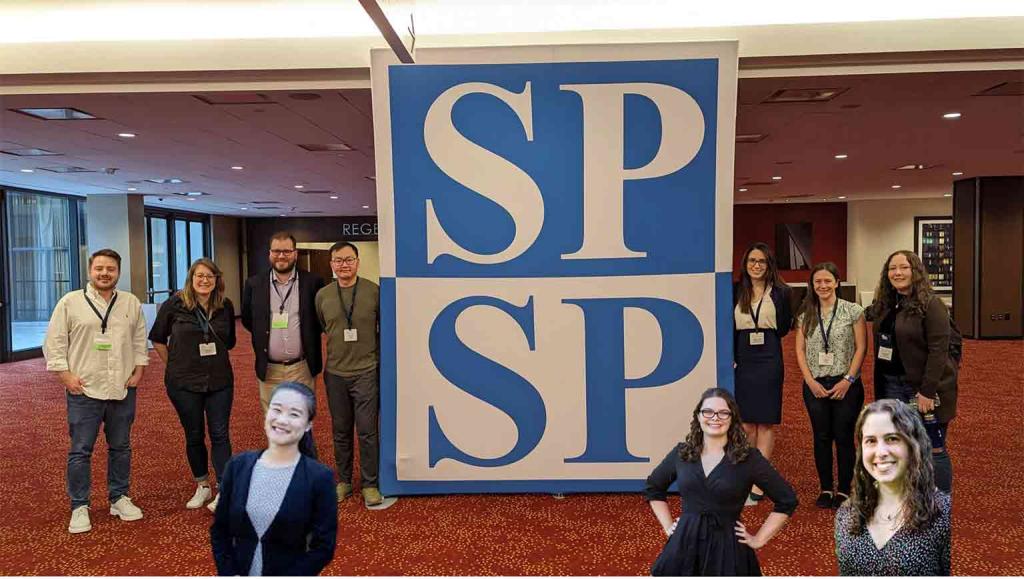 People standing around a large SPSP logo in a hotel lobby