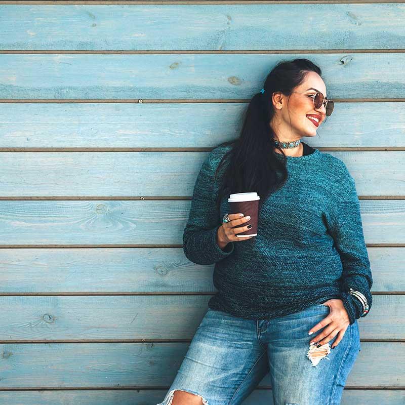 Woman smiling and holding cup of coffee