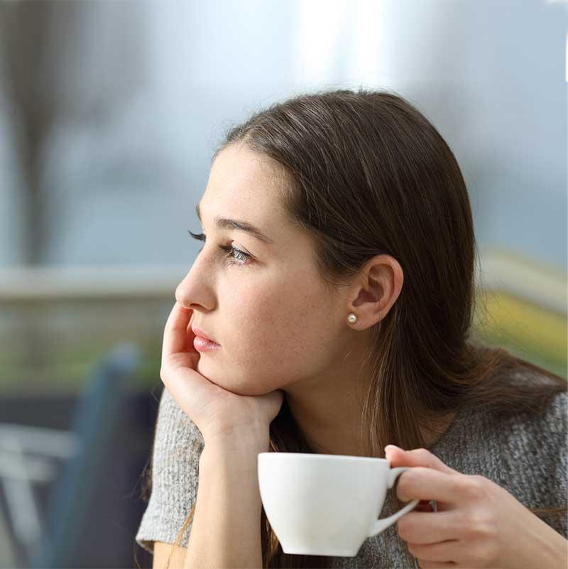 Young woman holding a cup looking to her side