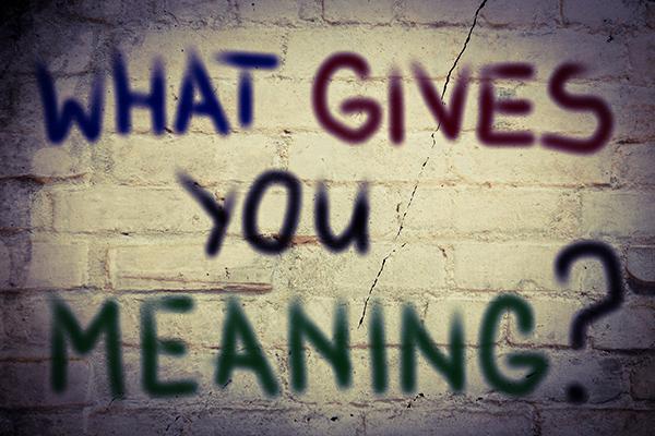 "What gives you meaning" in graffiti text over a brick background