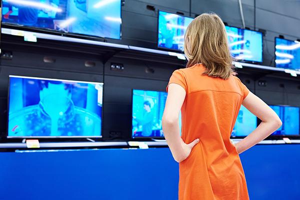 Image of young woman looking at TV screens all playing the same video