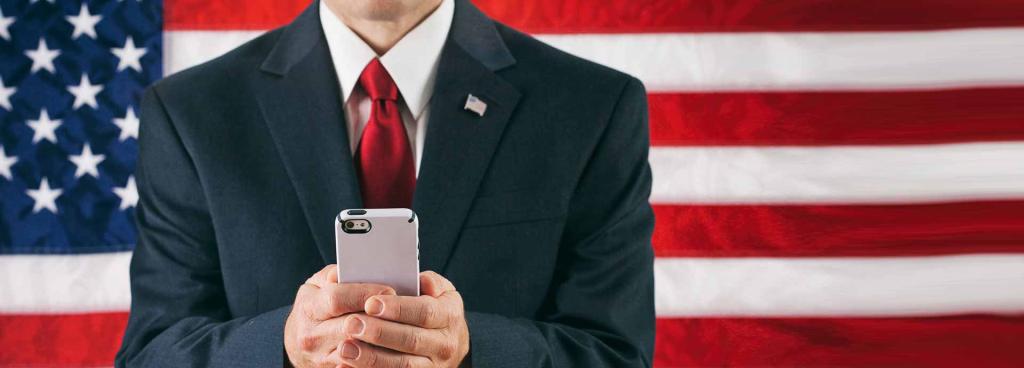 Male Politician Texting On Smart Phone in front of American Flag