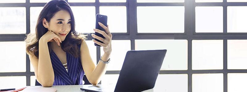 Young asian business woman holding smartphone taking selfie