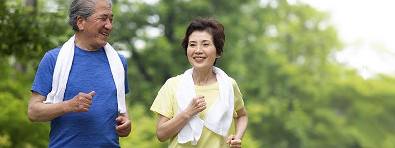 Older Asian couple jogging outdoors