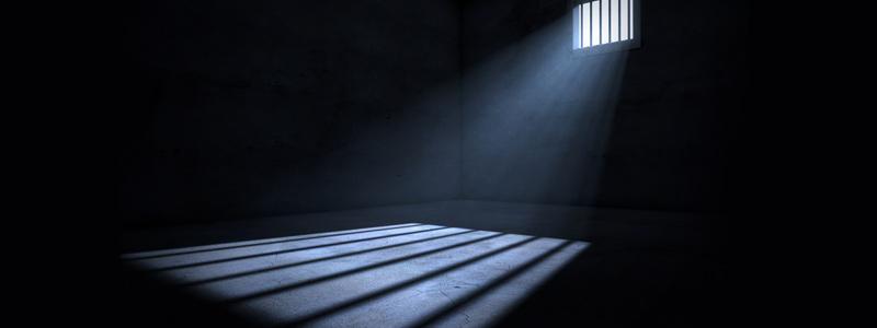 Image of light entering an empty dark jail cell